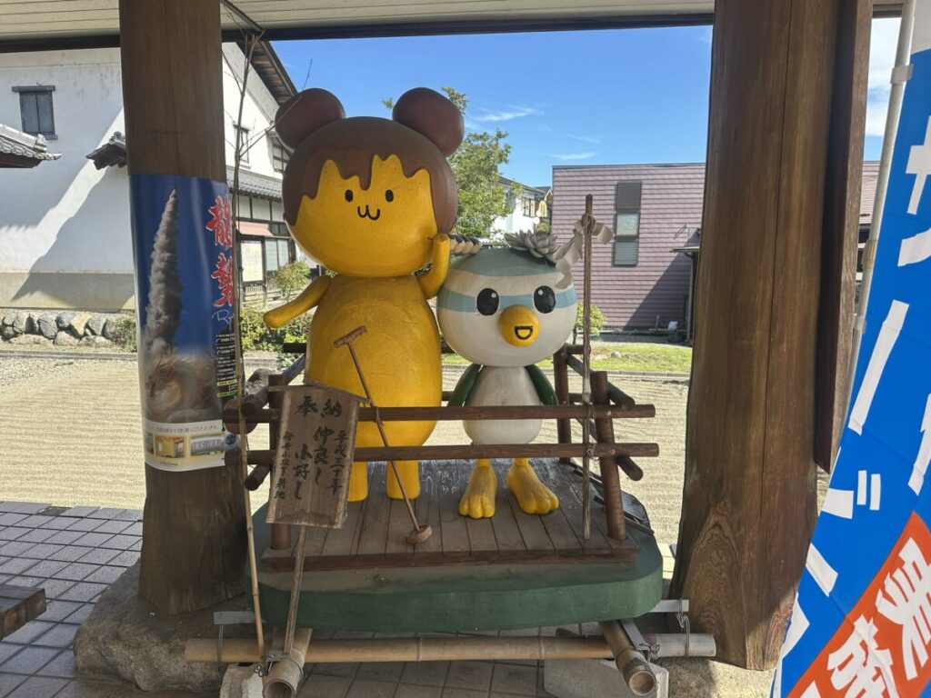 龍勢祭りのポスターと並ぶぽてくま君の像