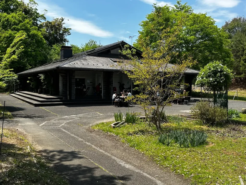 新緑に囲まれた秩父ミューズパーク内のカフェ「MAPLE BASE（メープルベース）」の外観とテラス席