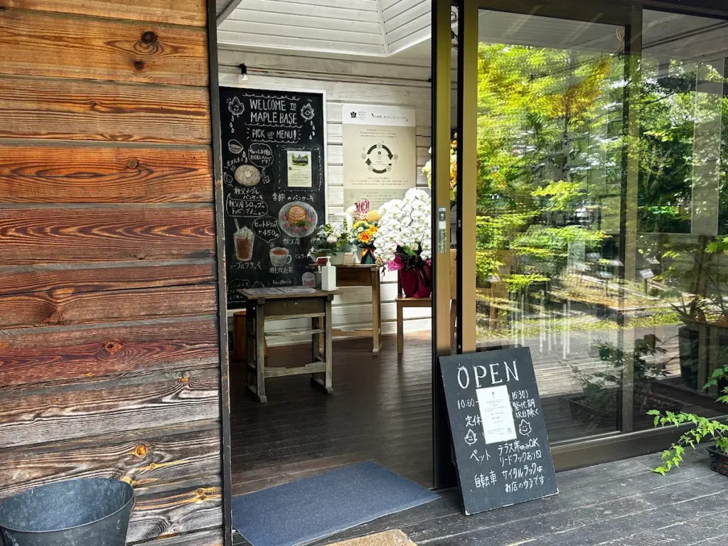 カフェ「MAPLE BASE」の入り口に置かれたメニューボードと10周年を祝う胡蝶蘭などの花